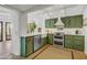 Well-lit kitchen features stainless appliances, custom lighting, and green cabinets at 5710 E Camelback Rd, Phoenix, AZ 85018