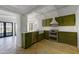 Modern green kitchen featuring stainless steel appliances, white counters and tiled floors at 5710 E Camelback Rd, Phoenix, AZ 85018