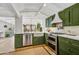 Well-appointed kitchen boasts stainless appliances, a large farmhouse sink, and olive green cabinets at 5710 E Camelback Rd, Phoenix, AZ 85018