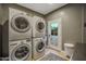 Convenient laundry room featuring stacked washer and dryer units and outdoor access at 5710 E Camelback Rd, Phoenix, AZ 85018