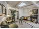 Cozy living room featuring a grand fireplace, skylight, and comfortable seating near an open window at 5710 E Camelback Rd, Phoenix, AZ 85018