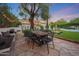 Inviting outdoor dining area on a stone patio with a large wood table and string lights at 5710 E Camelback Rd, Phoenix, AZ 85018