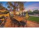 Inviting outdoor dining area on a stone patio with a large wood table and string lights at 5710 E Camelback Rd, Phoenix, AZ 85018