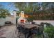 Charming outdoor patio with fireplace, dining table, built-in seating and string lights at 5710 E Camelback Rd, Phoenix, AZ 85018