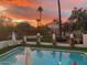 Inviting pool area with an umbrella, potted plants and lounge chairs, ideal for relaxation at 5710 E Camelback Rd, Phoenix, AZ 85018