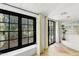Bright sun room with large windows offering lush outdoor views, tiled floors, and block glass window at 5710 E Camelback Rd, Phoenix, AZ 85018