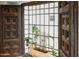 Unique window with a decorative grill, wood trim, and views of greenery, adding a touch of charm to the home at 5710 E Camelback Rd, Phoenix, AZ 85018