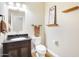 Well-lit half-bathroom with dark vanity, granite countertop, and decorative wall art at 6206 W Buckhorn Trl, Phoenix, AZ 85083