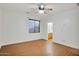 Bright bedroom featuring hardwood floors, a ceiling fan and window views, and a bathroom entrance at 6206 W Buckhorn Trl, Phoenix, AZ 85083