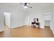 Bedroom with wood floors, ceiling fan, vanity with stool, and doors to a bathroom and closet at 6206 W Buckhorn Trl, Phoenix, AZ 85083