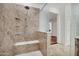 Walk-in shower with rainfall showerhead, built-in seating, grab bars, and decorative tile surround at 6206 W Buckhorn Trl, Phoenix, AZ 85083