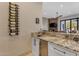 Close-up of the bar area with granite counters, a wine rack, and a mini fridge for entertaining guests at 6938 E Lomas Verdes Dr, Scottsdale, AZ 85266