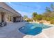 Backyard with covered patio, swimming pool, desert landscaping, and waterfall feature at 6938 E Lomas Verdes Dr, Scottsdale, AZ 85266