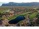 Stunning aerial view of the golf course community with water features, lush greenery, and mountain backdrop at 9161 E Superstition Mountain Dr, Gold Canyon, AZ 85118