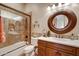 Well-lit bathroom featuring a walk-in shower, a bathtub and a round mirror at 9161 E Superstition Mountain Dr, Gold Canyon, AZ 85118