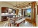 A well-lit dining area with a wine fridge and views of an outdoor kitchen and seating area at 9161 E Superstition Mountain Dr, Gold Canyon, AZ 85118