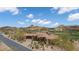 Aerial view of an estate home with a grand entrance, desert landscaping, and a pristine golf course nearby at 9161 E Superstition Mountain Dr, Gold Canyon, AZ 85118
