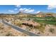 Aerial view of an estate home with a grand entrance, desert landscaping, and a pristine golf course nearby at 9161 E Superstition Mountain Dr, Gold Canyon, AZ 85118
