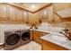 Well-organized laundry room with custom cabinetry, granite countertops, and modern washer and dryer at 9161 E Superstition Mountain Dr, Gold Canyon, AZ 85118