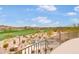 Balcony view of a backyard featuring a luxurious pool, spa, and beautifully landscaped desert surroundings and golf course at 9161 E Superstition Mountain Dr, Gold Canyon, AZ 85118