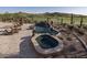Relax in the backyard oasis with a pool, hot tub, lounge chairs, and views of the golf course beyond at 9161 E Superstition Mountain Dr, Gold Canyon, AZ 85118