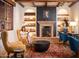 Inviting reading room featuring a cozy fireplace, bookshelves, comfortable seating, and natural light at 9161 E Superstition Mountain Dr, Gold Canyon, AZ 85118