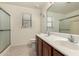 Bright bathroom features a double sink vanity with a large mirror and a shower with sliding glass doors at 10312 W Mazatlan Dr, Arizona City, AZ 85123