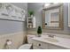 Charming powder room with white wainscoting, and decorative framed mirror at 10718 E Fenimore Rd, Mesa, AZ 85207