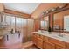 Bathroom with a double sink vanity, shower with curtain and warm paint tones at 10718 E Fenimore Rd, Mesa, AZ 85207