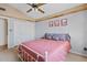 Cozy bedroom with a ceiling fan, neutral tones and a large closet with bi-fold doors at 10718 E Fenimore Rd, Mesa, AZ 85207