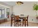 Bright dining area with tan tile flooring, modern lighting, and large window at 10718 E Fenimore Rd, Mesa, AZ 85207