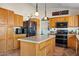 Well-lit kitchen featuring an island, wooden cabinetry, and modern appliances at 10718 E Fenimore Rd, Mesa, AZ 85207