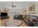 Bright living room with a vaulted ceiling, ceiling fan, and large windows for natural light at 10718 E Fenimore Rd, Mesa, AZ 85207