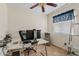 Home office with a glass desk, comfortable chair, and natural light at 10718 E Fenimore Rd, Mesa, AZ 85207