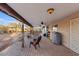 Covered brick patio featuring comfortable seating, ceiling fans, and a view of the desert landscape at 10718 E Fenimore Rd, Mesa, AZ 85207