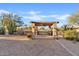 Tranquil outdoor space featuring a pergola with stone pillars and surrounding desert landscape at 10718 E Fenimore Rd, Mesa, AZ 85207
