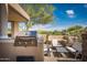 An outdoor kitchen features a built-in grill and bar seating with a view of the surrounding desert at 11199 E Prospect Point Dr, Scottsdale, AZ 85262