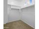 Walk-in closet with a functional layout, carpeted floor, and ample shelving and rod space at 11500 E Cochise Dr # 2067, Scottsdale, AZ 85259