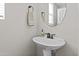Bathroom featuring a white pedestal sink, oval mirror, and neutral decor at 12343 W Essig Way, Peoria, AZ 85383