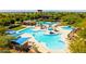 Aerial view of resort-style pool, featuring palm trees, shade structures, and plenty of lounge chairs at 12343 W Essig Way, Peoria, AZ 85383