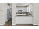 Updated kitchen with white cabinets, stainless steel appliances, and breakfast bar with stone countertops at 12343 W Essig Way, Peoria, AZ 85383