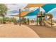 Community playground featuring shade structures, a slide, climbing features, and a sand pit at 12343 W Essig Way, Peoria, AZ 85383