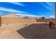 Spacious gravel backyard featuring a block fence, scattered desert plants, and blue skies at 1250 E Eric Pl, Casa Grande, AZ 85122