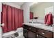 Bathroom with a single sink vanity, dark wood cabinets, and red shower curtain at 1250 E Eric Pl, Casa Grande, AZ 85122