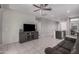 Open-concept living room with tile floors, ceiling fan, and a breakfast bar leading to the kitchen at 1250 E Eric Pl, Casa Grande, AZ 85122