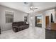 Open living room with white tile floors, neutral paint, and a comfy brown sofa near sliding glass doors at 1250 E Eric Pl, Casa Grande, AZ 85122