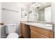 Bathroom features a white toilet, wooden vanity, and a shower with glass doors at 131 N Higley Rd # 215, Mesa, AZ 85205