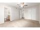 Bedroom with a ceiling fan, closet doors, and adjacent bathroom at 131 N Higley Rd # 215, Mesa, AZ 85205