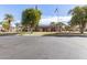 A well-maintained clubhouse with an American flag, surrounded by green lawns and mature trees on a clear day at 131 N Higley Rd # 215, Mesa, AZ 85205