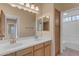 Well-lit bathroom featuring dual sinks, wooden cabinets, and large mirror at 1538 N Atwood --, Mesa, AZ 85207